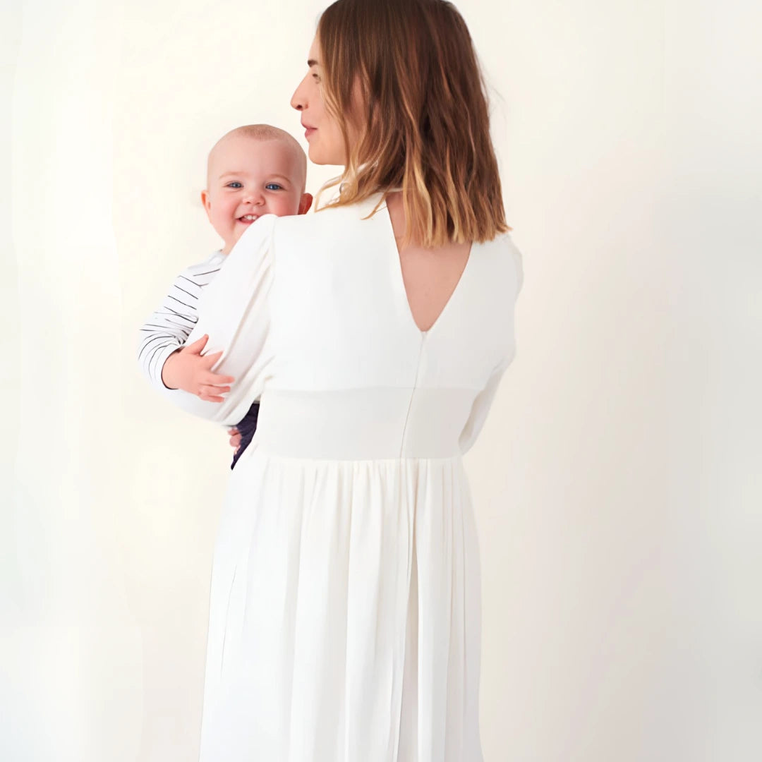 Stylish new mother in Chelsea in a ivory dress that works for pregnancy and breastfeeding with discreet hidden zips - good maternity clothes for women with high disposable income luxury style