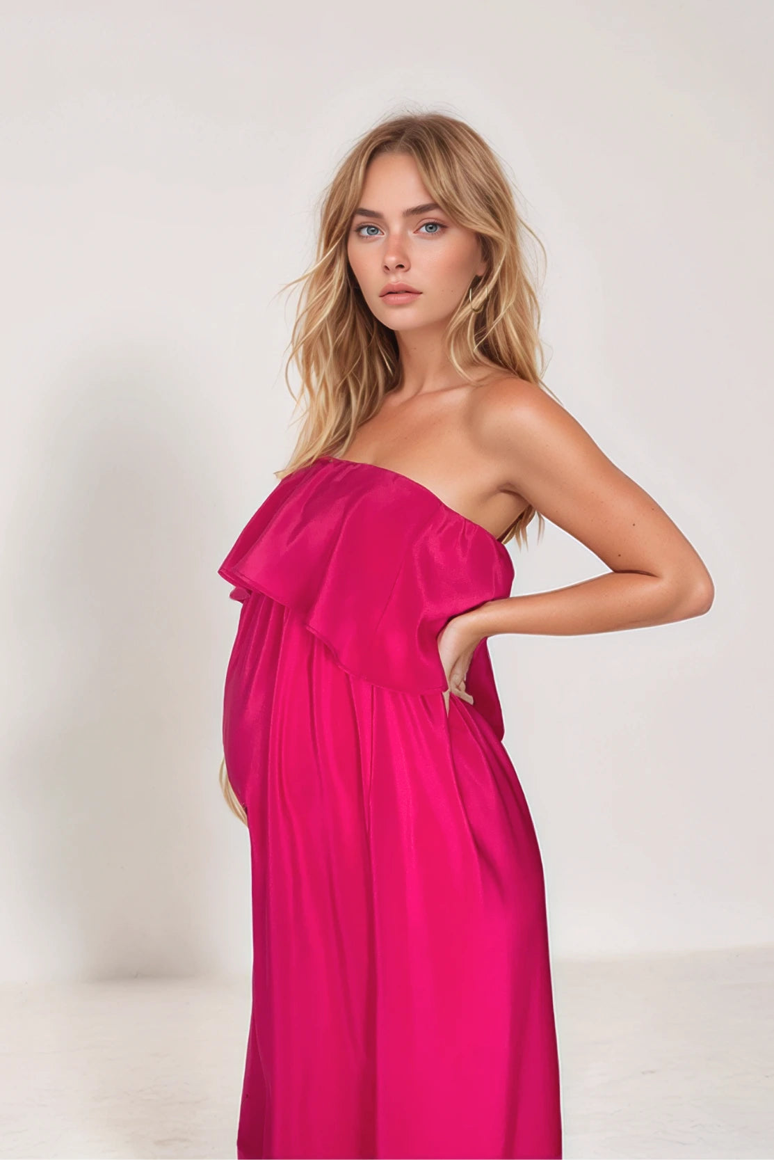 Stylish pregnant woman in a statement pink evening dress - a fabulous designer style for dressy occasions by luxury pregnancy brand CARI