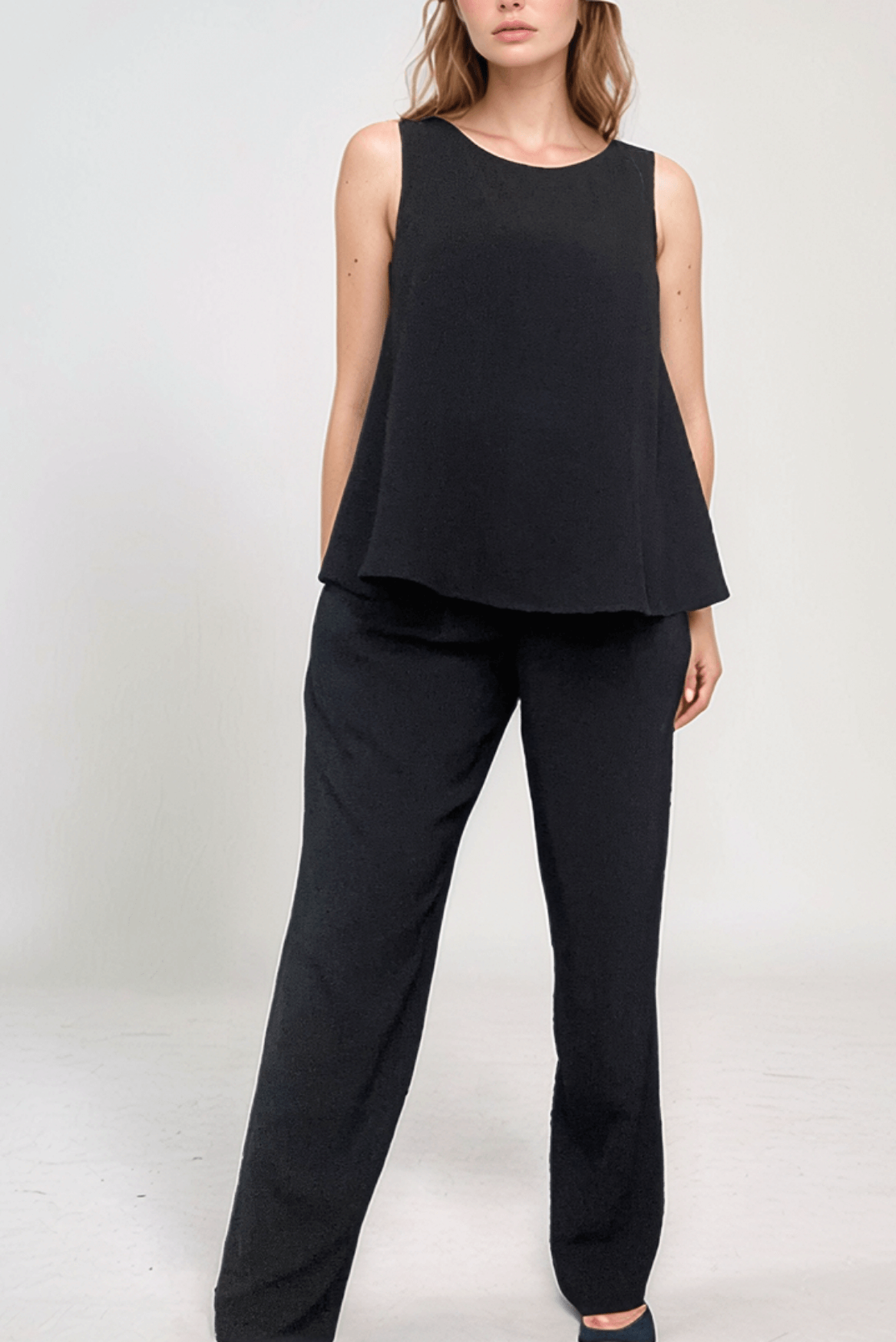Pregnant woman wearing a sophisticated black business suit suitable for maternity with black maternity trousers and matching black top suitable for events and business conferences